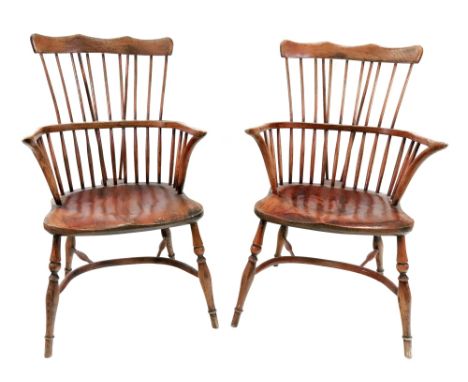 A pair of ash and elm Windsor elbow chairs, with comb backs, pointed arm terminals, solid seats, on baluster turned legs unit