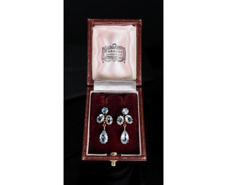 A pair of 9ct gold, aquamarine and ruby-set pendant earrings, the circular-cut claw-set aquamarines, suspending two oval-cut-
