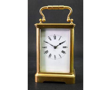A large brass cased carriage clock, early 20th century, the white enamel dial with Roman numerals, striking on a gong, in an 