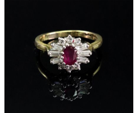 An 18ct gold, ruby and diamond ring, of cluster design, the central oval-cut ruby claw set to a surround of circular and bagu