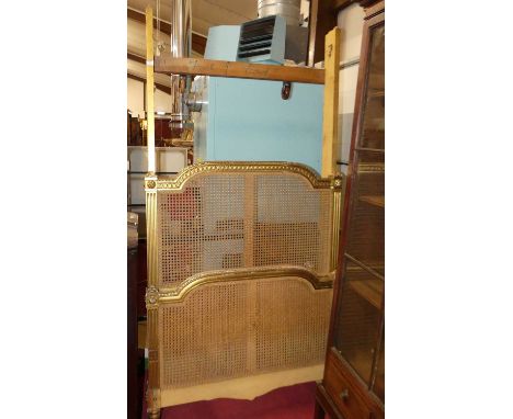 A circa 1900 French giltwood and cane inset single lit-en-bateau, having constructed base section with roller castors