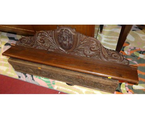 A floral relief carved oak wall shelf, length 129cm; together with a floral relief carved oak section of a frieze, length 111