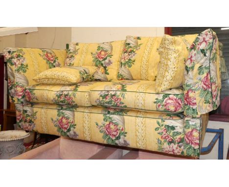 A yellow floral fabric decorated two-seater Knoll settee, raised on roller castors, w.183cmGot scratches to the right side.  
