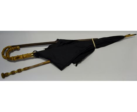 An early 20th century leather riding crop or swagger stick; a gentleman's unbrella; another; a parasol (4)