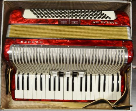 A Hohner Carena IIIM 120 bass piano accordion with five treble and two bass couplers in red pearloid finish with hard case