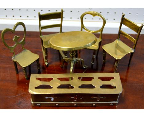 Victorian miniature brass furniture consisting of a tilt top tripod table, a fender and four chairs