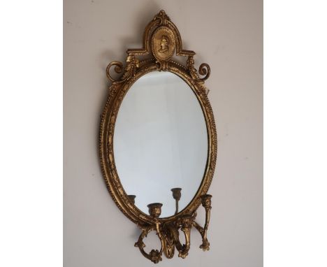 Regency style carved giltwood and gesso girandole mirror, oval plate with portrait cresting, three scrolled branches with urn