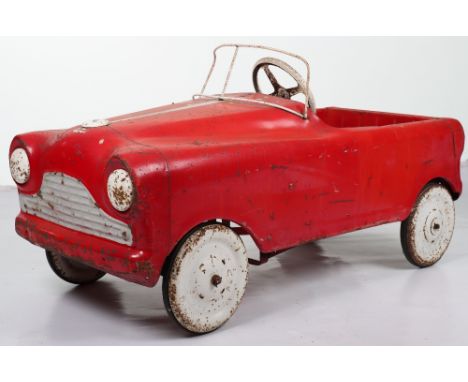 A Tri-ang pressed steel child’s pedal car, English 1960s, painted in red with white metal steering wheel and windshield, pain