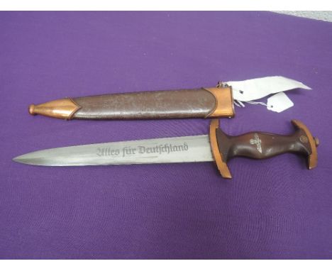 A World War II marine dagger and scabbard with copper plated fitting, blade engraved Alles Fur Deutschland
