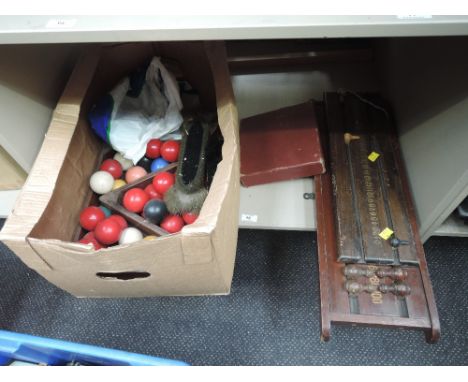 A shelf of vintage snooker and pool balls, scoreboard and accessories