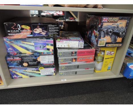 A shelf of modern toys and games including Ban Dai and Playmates Star Trek  space crafts, King Star Trek puzzles, Simpsons Ho