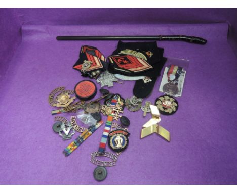 A collection of military badges and buttons plus a small sword stick with replacement scabbard