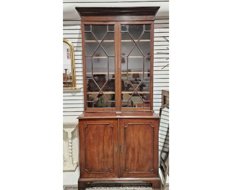 Mahogany library bookcase, the top glazed section with four adjustable shelves, the base with two door cupboard having pigeon