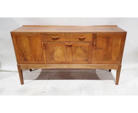 1969/70 Oliver Morel Cotswold School walnut sideboard having slight raised edge to the back, central frieze drawer with curve