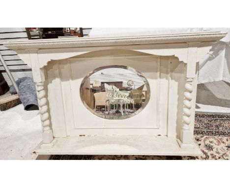 Early 20th century white painted overmantel mirror, the bevelled edged oval glass panel over a single shelf, with barleytwist