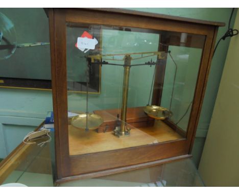Complete set of weighing scales in 4 sided glass case with box of weights 