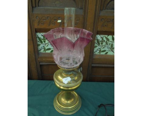 Brass oil lamp with pink decorative shade