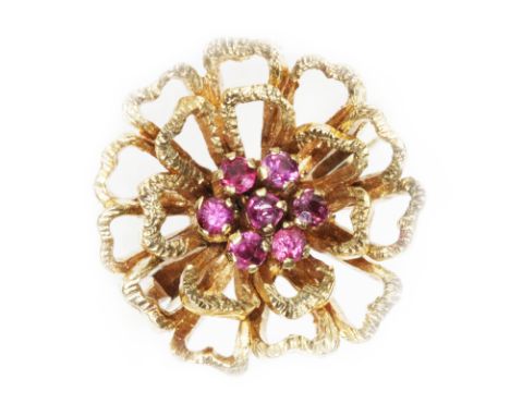 A 9ct yellow gold ruby cluster ring, textured flower head set with seven small stones, hallmarked; sponsor 'S&amp;K', London 