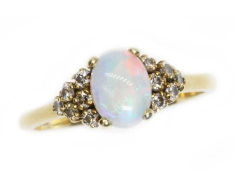 An 18ct yellow gold opal and diamond ring, the central oval cabochon measuring approximately 8.10mm x 6mm, depth 2.64mm, twel
