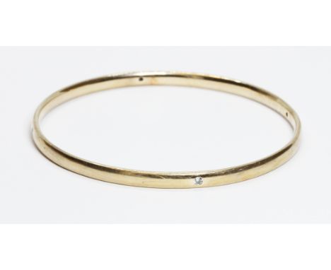 A 9ct gold diamond bangle, four round diamonds in rub over setting and weighing approximately 0.16cts in total, hallmarked; s