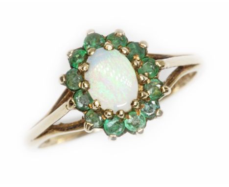 A hallmarked 9ct gold opal and emerald ring, the cluster measuring approximately 12mm x 10mm, gross weight 2.6g, size Q.  Con
