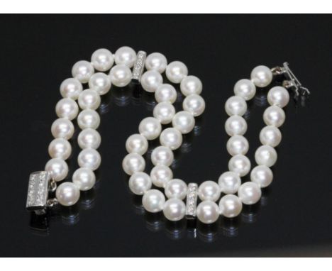 An 18ct white gold, cultured pearl and diamond bracelet, two strands of uniform pearls, approximately 6mm to 6.3mm in diamete