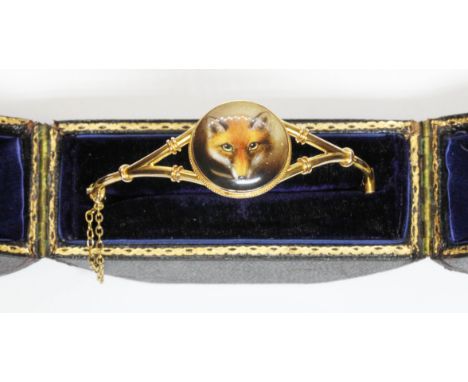 A late Victorian or Edwardian antique bangle of hinged form and with hand painted porcelain miniature depicting a fox's head,