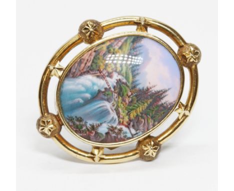 An early 20th century continental brooch with painted enamel cabochon depicting a Swiss mountain scene entitled verso 'Chute 