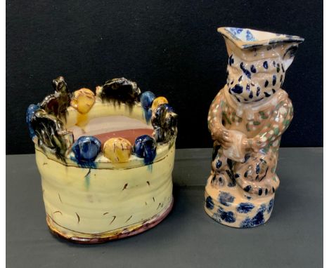 A early 18th century Staffordshire jug, 28cm high, an unusual planter in tones of yellows, blues and greens, 20cm (2) 