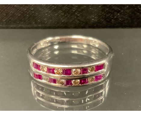 A ruby and diamond ring, with two rows of alternating square step cut rubies and round brilliant cut diamonds, total estimate