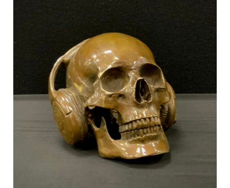 A bronzed metal model of skull wearing headphones,18cm high 