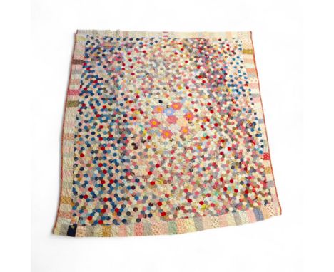 An English cotton hexagon hand made and hand pieced quilt, made from a large variety of printed dress fabrics from 19th centu