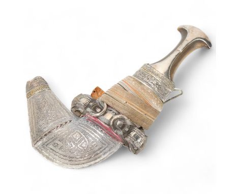 An Oman ceremonial jambiya dagger, late 19th/early 20th century, with horn handle and woven fabric belt, length 31cm 