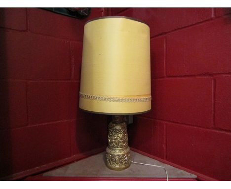 An embossed gilt decorated table lamp with shade