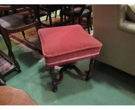 Circa 1840 a walnut stool the concave edged seat over turned legs joined by an 'X' stretcher with turned central finial, 50cm