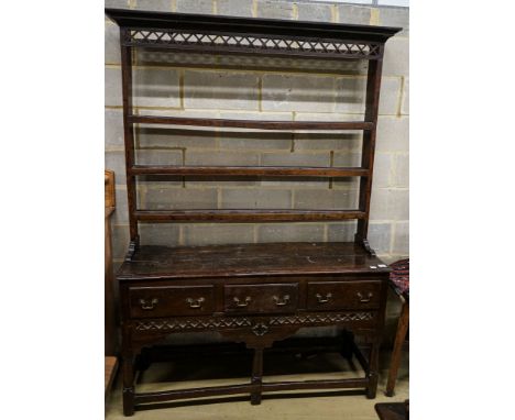 A mid 18th century oak dresser, with pierced cornice and three shelf rack over three drawers, with pierced frieze and turned 