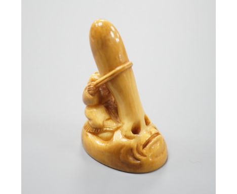 A Japanese ivory netsuke of a man climbing a giant Tengu noh mask, 19th century, 4.2cm