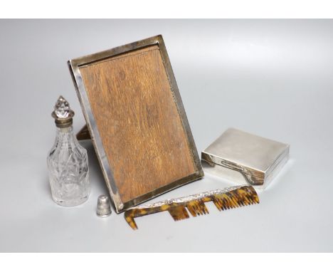 A silver mounted cigarette box, a silver mounted photograph frame, a silver thimble, a silver mounted comb(a.f.) and a silver