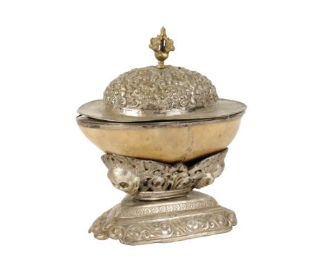 SILVER MOUNTED HUMAN SKULL KAPALA, TIBET, 19TH CENTURY, the silver lined bowl raised on a foliate chased triform base decorat