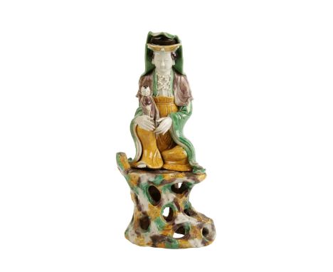 FAMILLE VERTE SEATED GUANYIN, KANGXI PERIOD, the deity seated in meditative pose, one hand securing a small child, the other 