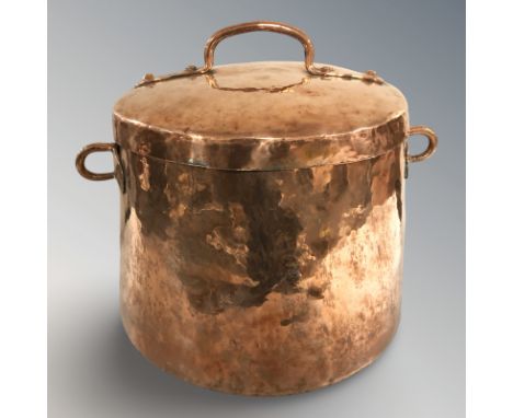 A copper twin handled cooking pot with lid, height 35 cm.