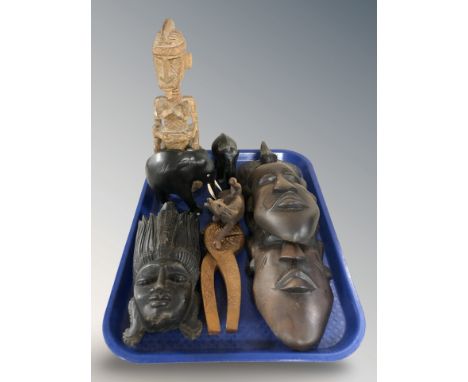 A group of African carved hardwood masks, ebony elephants, a nutcracker, figures, etc.