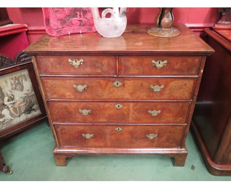 An early 18th Century walnut two over three chest of drawers on bracket feet 