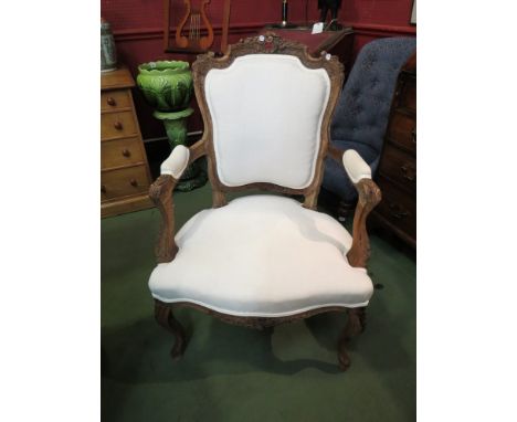 A light oak white upholstered armchair with carved floral detail, on cabriole legs 