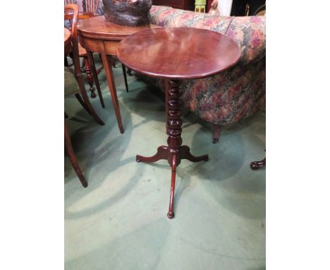 A George III mahogany wine table the oval tilt top over tapering bobbin turned column and tri-pod base, on bun feet