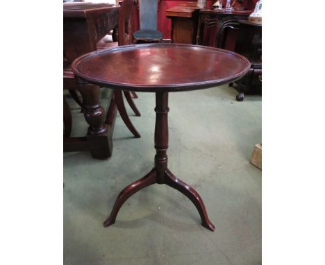 A circa 1780 mahogany wine table, the dished circular tilt top over a turned column and tripod base with outswept feet suppor