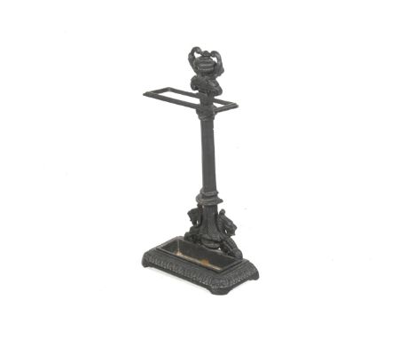 A cast metal stick stand. Painted black, modelled as an urn toping a corinthian column, with a gadrooned edge border around t