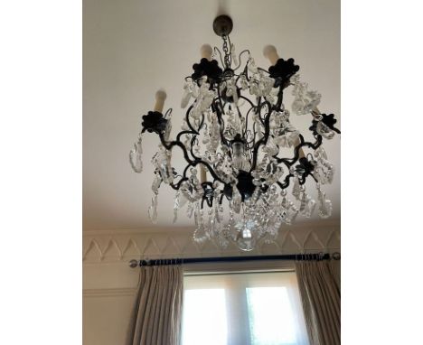 A contemporary metal framed chandelier, Having three tiers, the upper tier with eight branches all suspended with glass dropl