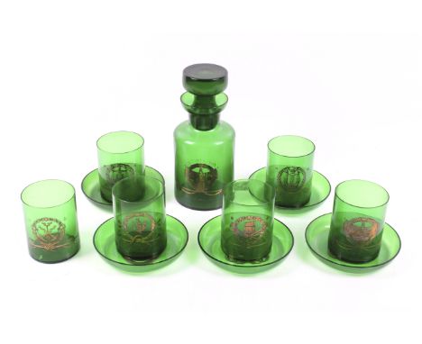 A green glass decanter, six beakers and five plates. Possibly of masonic or workers guild interest, each item bearing gilt sy
