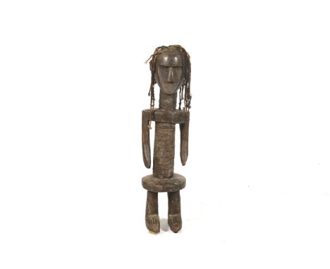 Ethnographic Tribal Art - an African tribal female figure. Of standing form, with elongated torso wrapped in string and with 